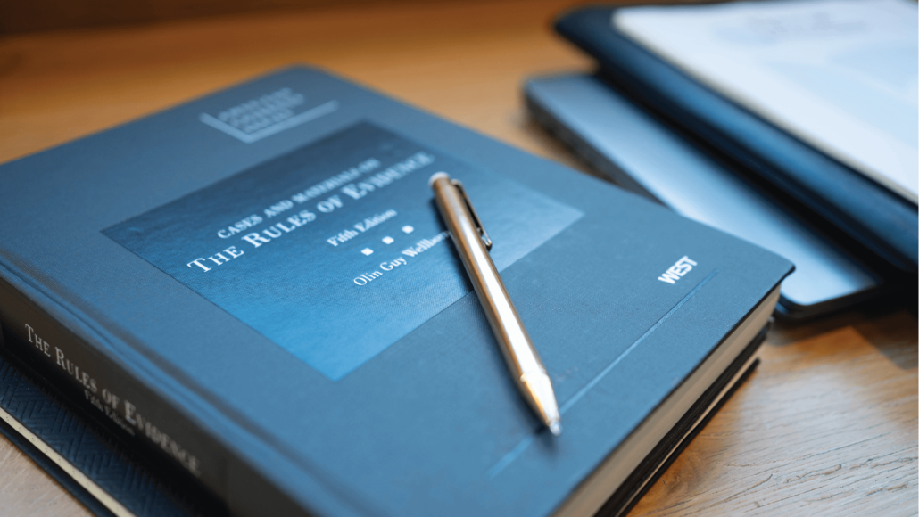 A legal book and a golden pen over the table | IQ Law Group